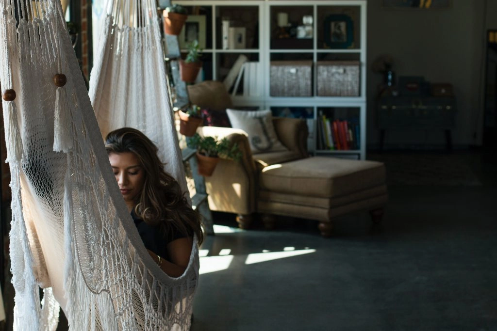 a girl reading on an indoor hammock