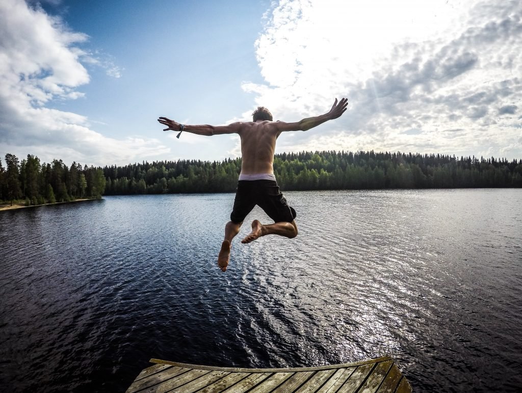 a man jumping into a lake