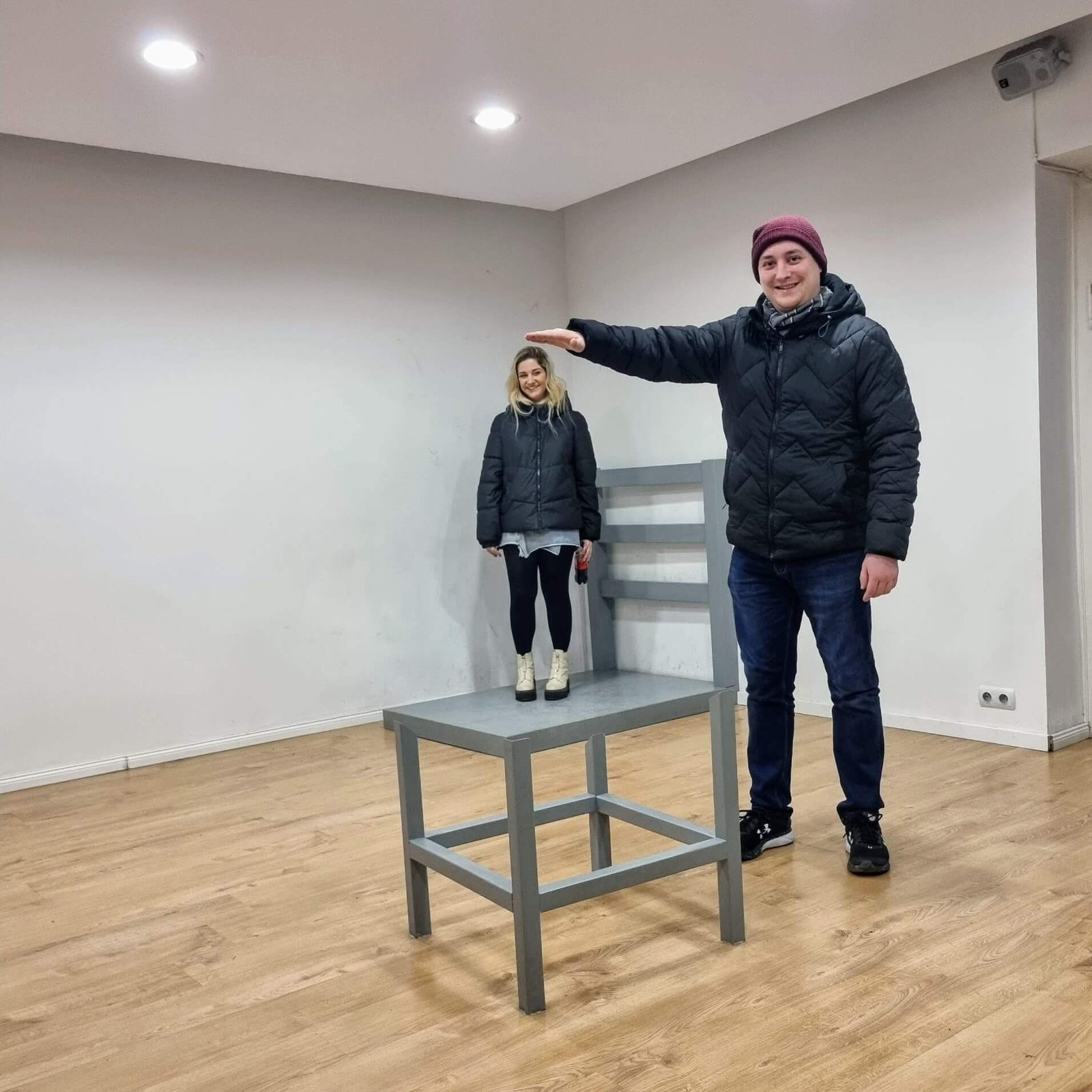 an optical illusion of a giant chair with the author standing on it 