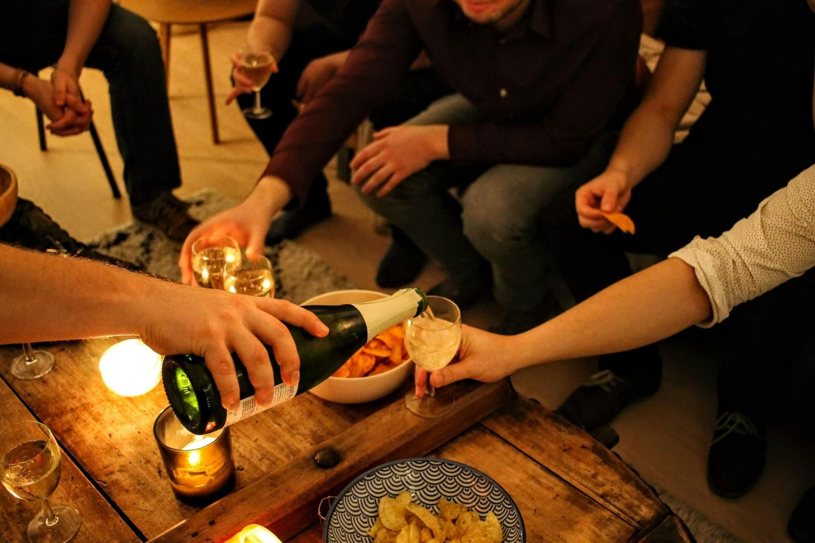 friends pouring one another a glass of wine